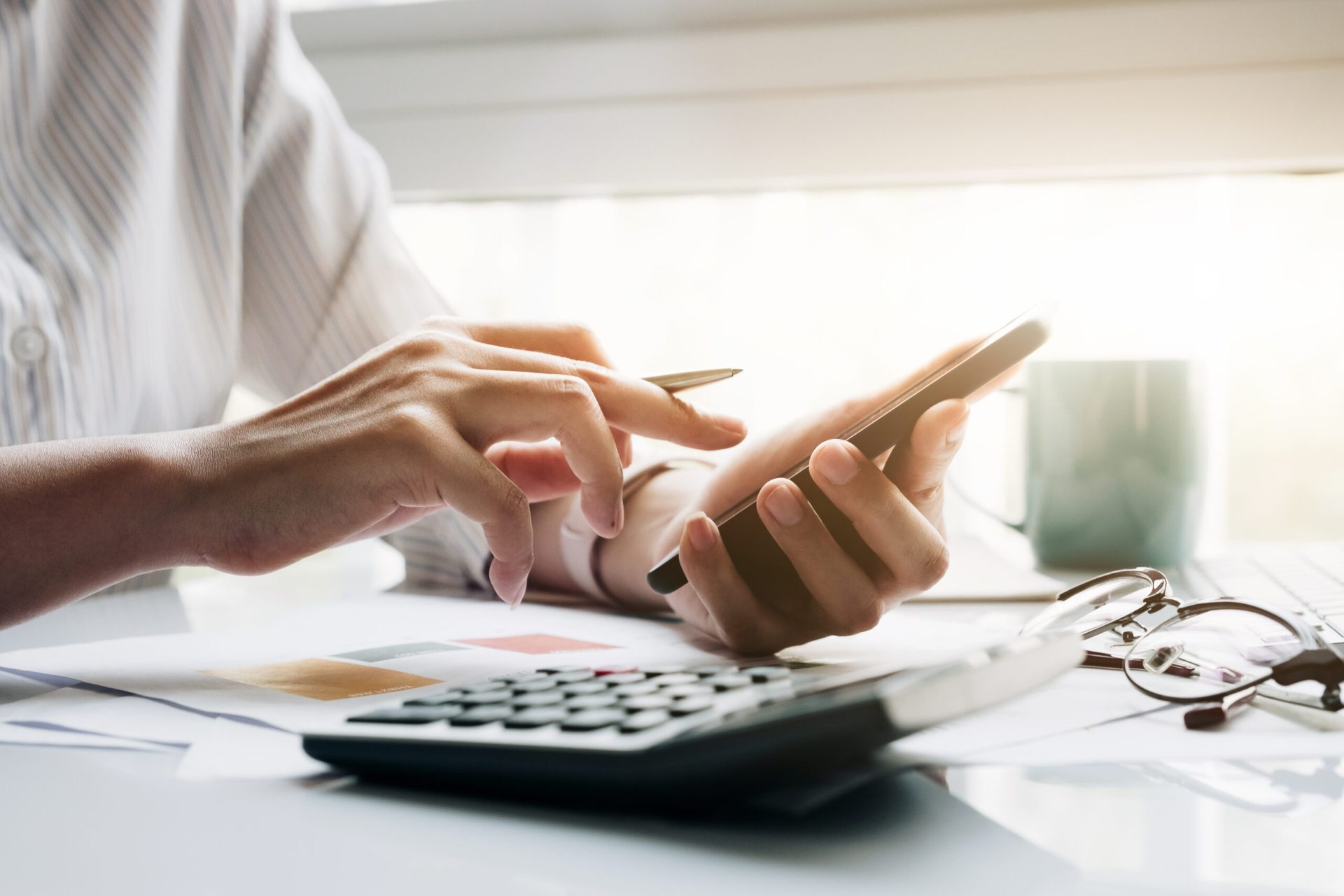 close up of businessman or accountant hand holding pen working o