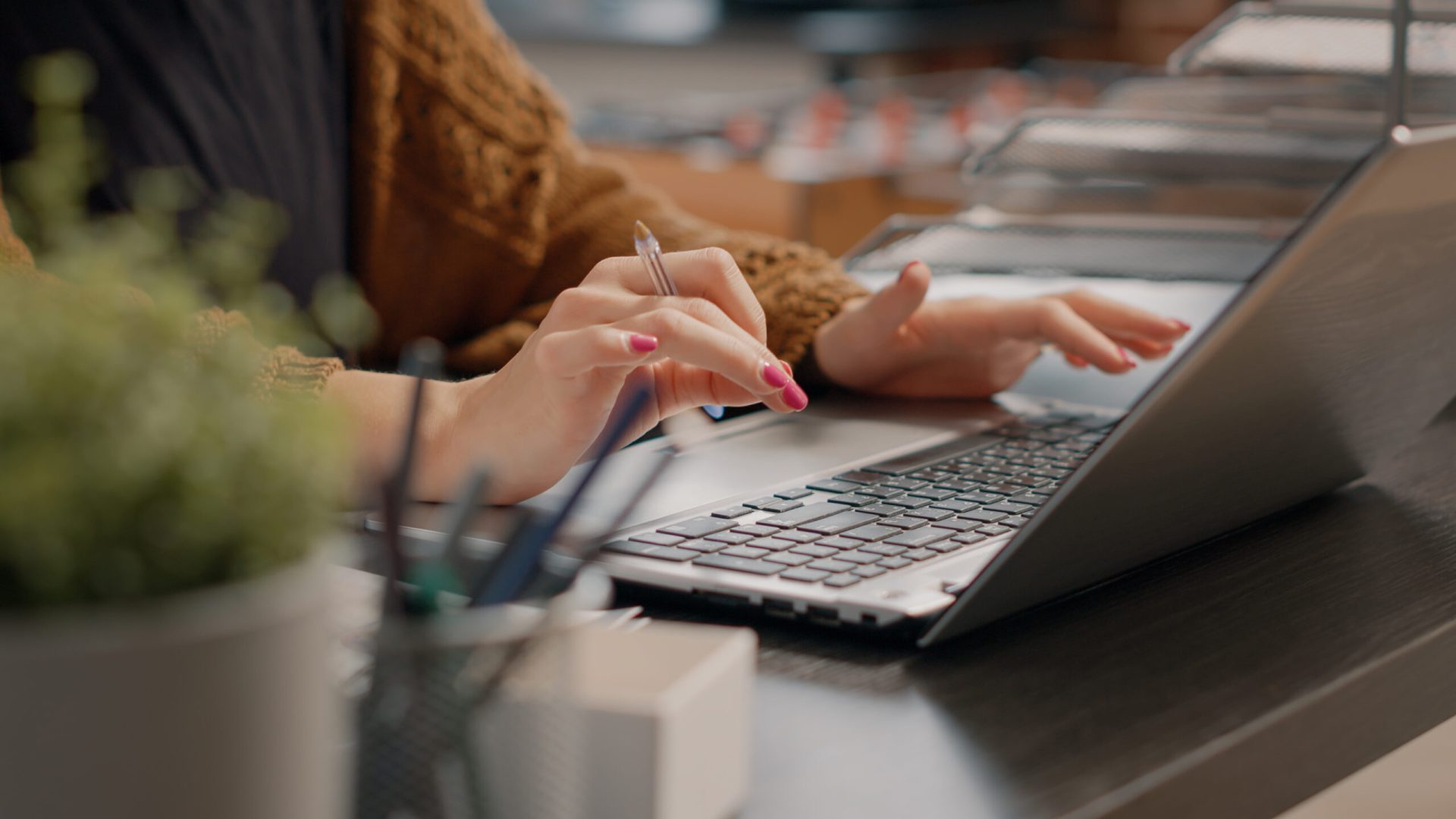 close up of woman typing on laptop keyboard to work